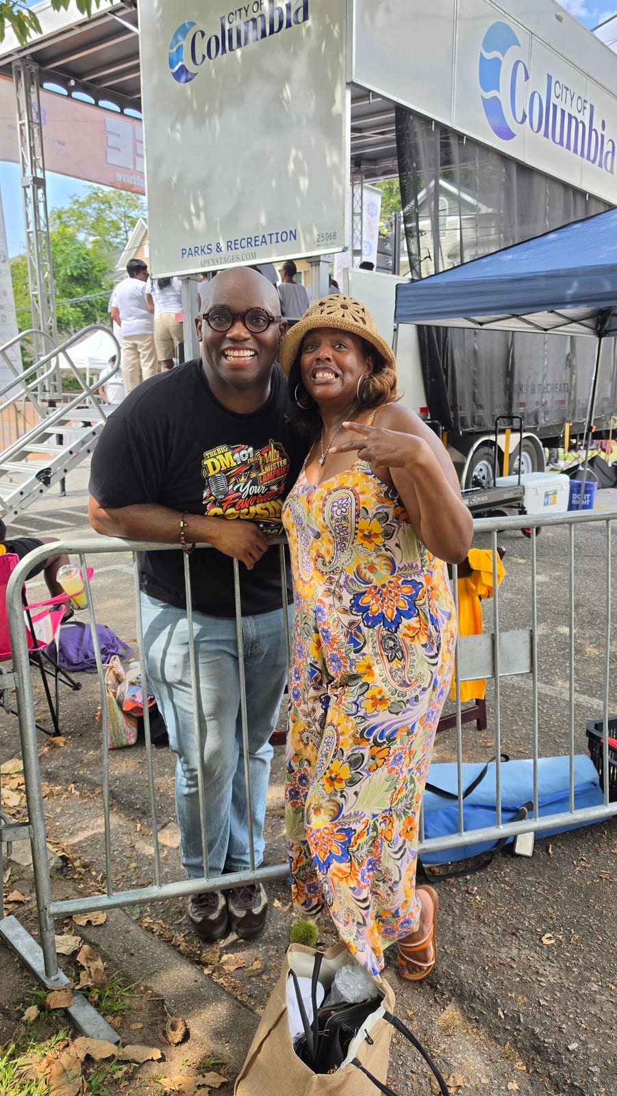 Two community members standing beside a City of Columbia event stage