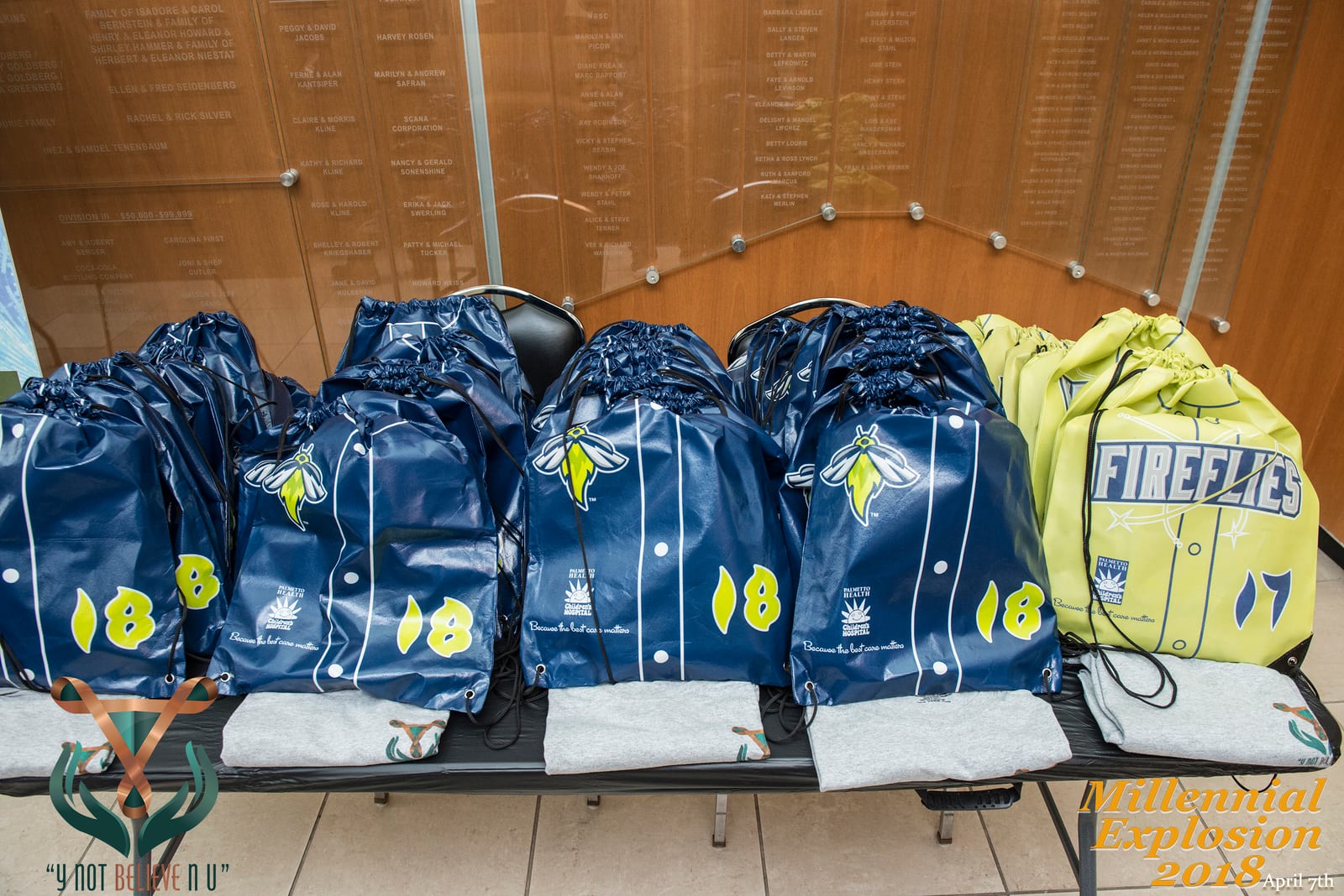 Event giveaway bags and shirts arranged on a table