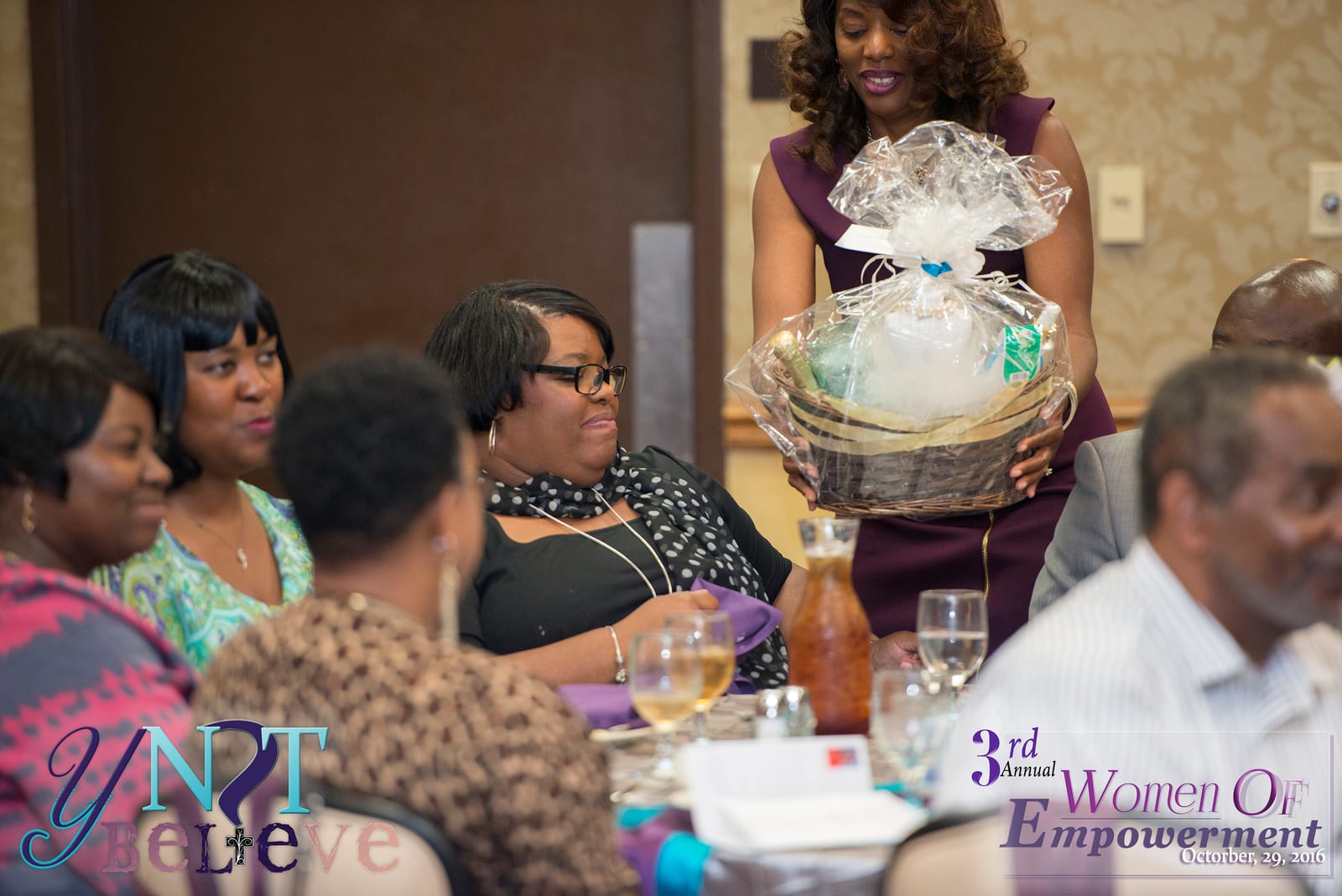 Robin Clark presenting a gift basket to a guest at a community empowerment event